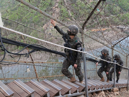 In this undated file photo provided by the Army, 7th Infantry Division troops patrol along barbed wire fences in the border county of Hwacheon, 89 kilometers northeast of Seoul. (PHOTO NOT FOR SALE) (Yonhap)