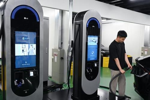 An LG Electronics employee charges an electric vehicle using a charger developed by HiEV Charger, an LG subsidiary, in this photo provided by LG on May 25, 2023. (PHOTO NOT FOR SALE) (Yonhap)
