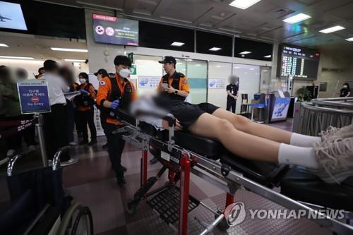 A student is moved to a hospital due to breathing difficulty after an airplane landed with a door open at Daegu International Airport on May 26, 2023. (Yonhap)