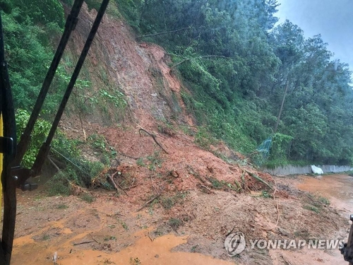 Una carretera está cubierta de lodo después de que las fuertes lluvias provocaran un deslizamiento de tierra en el condado de Seocheon, provincia de Chungcheong del Sur, el 14 de julio de 2023, en esta foto proporcionada por el condado.  (FOTO NO A LA VENTA) (Yonhap)