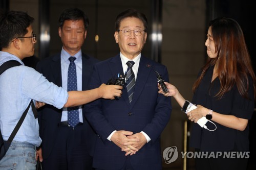 In this file photo, Democratic Party leader Lee Jae-myung (C) speaks to reporters after undergoing questioning at the Seoul Central District Prosecutors Office in southern Seoul on Aug. 18, 2023. (Yonhap)