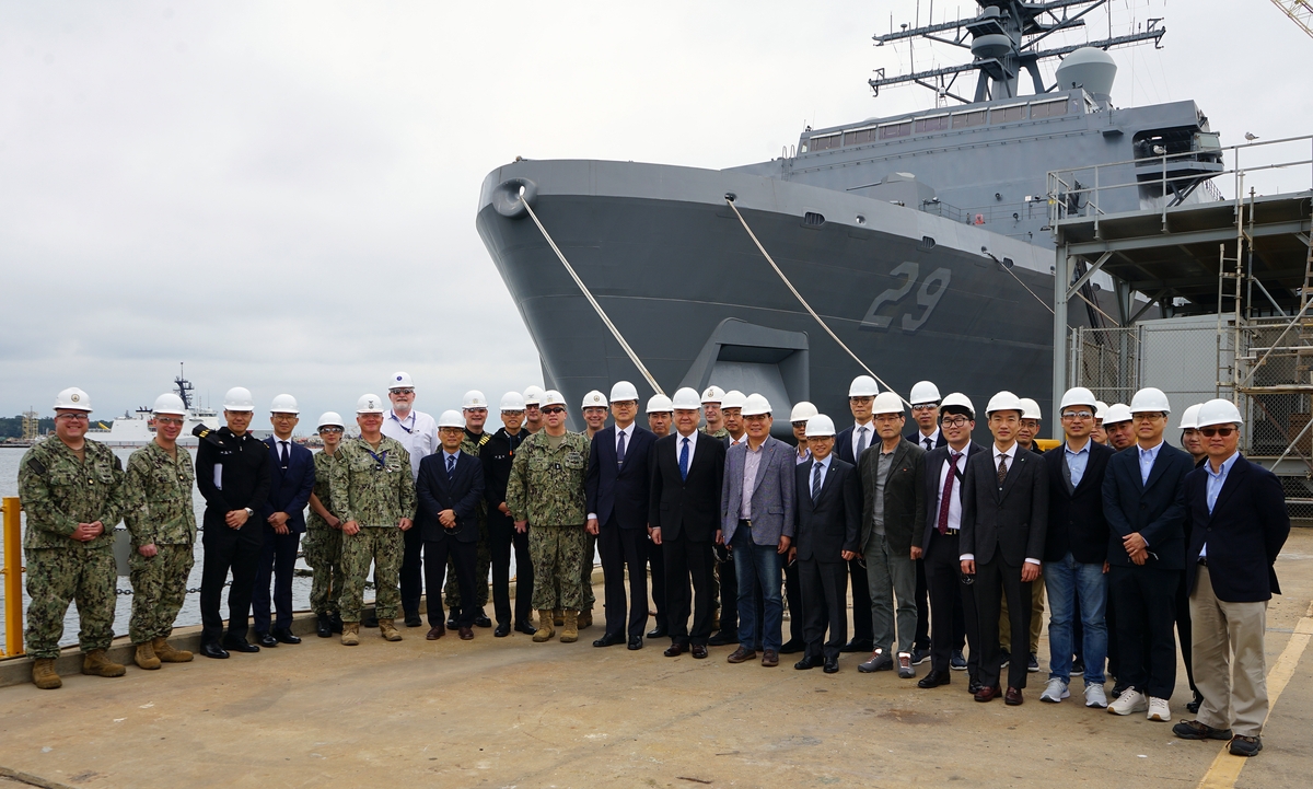 Officials from the Defense Acquisition Program Administration, HD Hyundai Heavy Industries, HJ Shipbuilding and Construction, SK Oceanplant and Hanwha Ocean pose for a photo with U.S. Naval Sea Systems Command officials at a Huntington Ingalls Industries shipyard in the United States, in this undated photo provided by DAPA on Nov. 17, 2023. (PHOTO NOT FOR SALE) (Yonhap)
