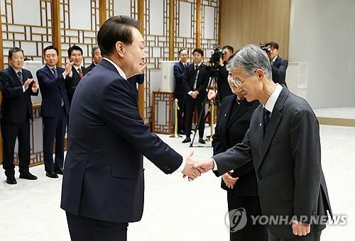This photo shows President Yoon Suk Yeol (L) shaking hands with Cho Hee-dae at the presidential office in Seoul on Dec. 8, 2023, during a ceremony to present him with a letter of appointment as the new Supreme Court chief justice. (Pool photo) (Yonhap)