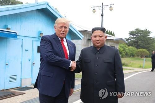 This photo, taken on June 30, 2019, shows then U.S. President Donald Trump (L) shaking hands with North Korean leader Kim Jong-un at the inter-Korean border truce village of Panmunjom. (Yonhap)