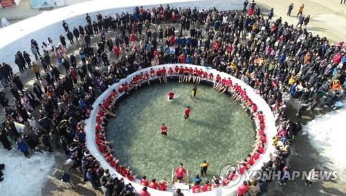 Esta fotografía de archivo proporcionada por la oficina del condado de Hwacheon muestra a turistas disfrutando de la pesca con las manos desnudas en Hwacheon, al noreste de Seúl.  (FOTO NO EN VENTA) (Yonhap)