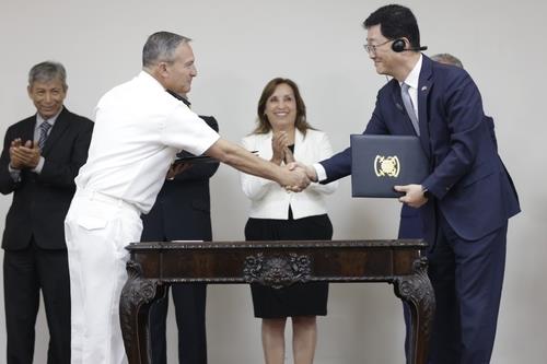 Joo Won-ho (R), head of HD Hyundai Heavy Industries' naval and special ship business unit, shakes hands with SIMA General Manager Cesar Augusto Benavides Iraola (R) after signing a 640.6 billion-won (US$463 million) contract for joint production of ships for the Peruvian Navy during a ceremony in Lima on April 16, 2024, in this photo provided by the Korean Embassy in Peru. (PHOTO NOT FOR SALE) (Yonhap)