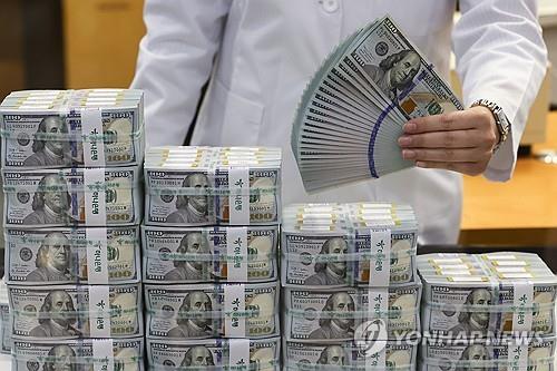 An official checks U.S. banknotes at the headquarters of Hana Bank in Seoul on May 7, 2024. (Yonhap)