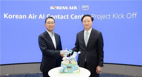 This photo taken May 20, 2024, shows Korean Air President Woo Kee-hong (R) shaking hands with Ham Kee-ho, CEO of AWS Korea, after signing a deal to develop a Korean Air AI Contact Center (AICC) platform at the Korean carrier's headquarters in Seoul. (PHOTO NOT FOR SALE) (Yonhap)