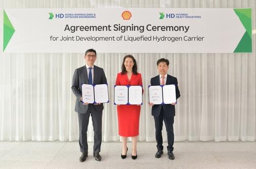 This undated photo provided by HD Hyundai Co. shows officials from HD Korea Shipbuilding & Offshore Engineering Co., Shell and HD Hyundai Heavy Industries Co. posing for a photo after signing a joint development agreement in Seongnam, south of Seoul. (PHOTO NOT FOR SALE) (Yonhap)