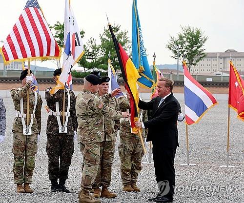 El ministro de Defensa alemán, Boris Pistorius (derecha), entrega la bandera alemana al general Paul LaCamera (tercero desde la izquierda), comandante del Comando de la ONU, durante una ceremonia que marca la admisión de Alemania en el comando multinacional en su sede en Pyeongtaek, a 60 kilómetros al sur de Seúl, el 2 de agosto de 2024. (Foto del grupo) (Yonhap)