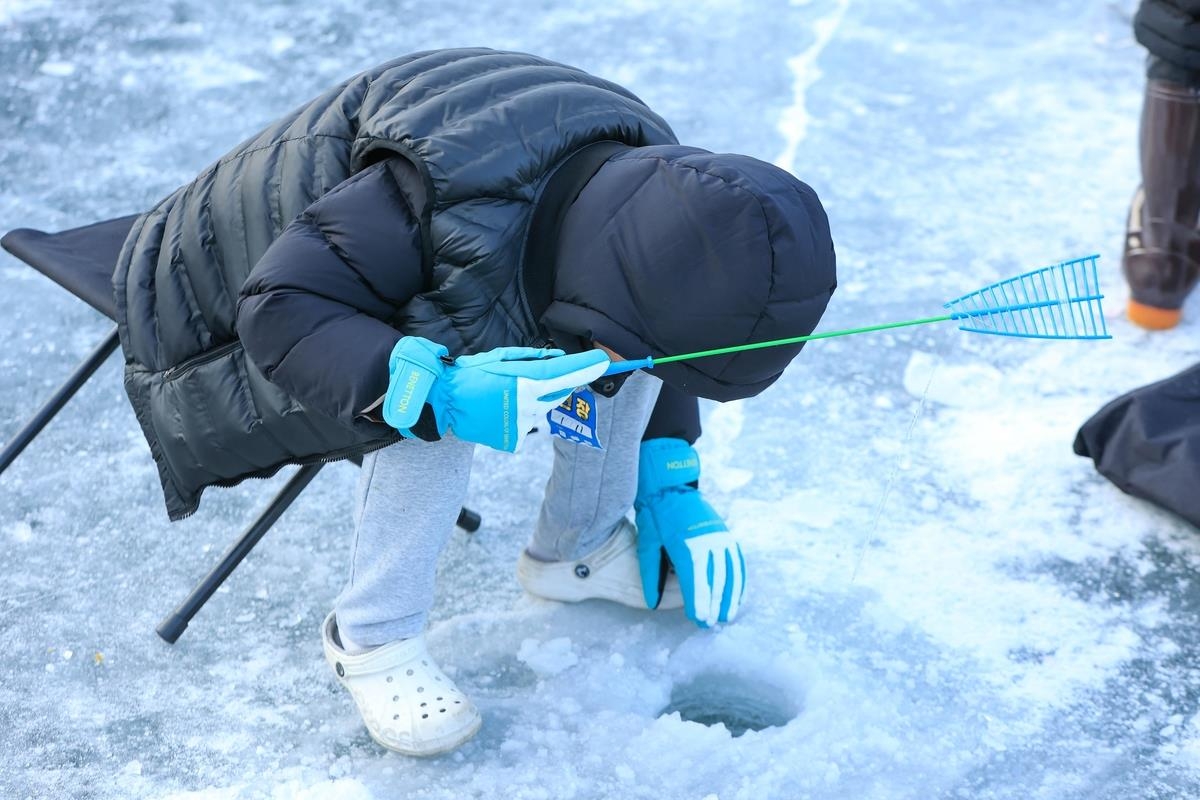 Un participante intenta atrapar "sancheoneo" mientras pescaba en hielo en el Festival de Hielo Hwacheon Sancheoneo 2025 en Hwacheon, provincia de Gangwon, el 11 de enero de 2025. (Yonhap)