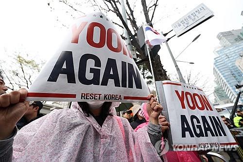 Supporters of former President Yoon Suk Yeol hold pickets reading "Yoon Again" in front of the Seoul Central District Court in southern Seoul on April 14, 2025. (Yonhap)