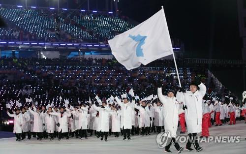 La délégation intercoréenne marche ensemble le vendredi 9 février 2018 derrière le drapeau de l'unification lors de la cérémonie d'ouverture des Jeux olympiques d'hiver 2018 au stade olympique de PyeongChang.