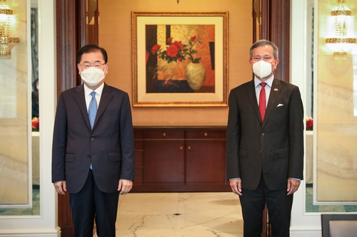 Le ministre des Affaires étrangères Chung Eui-yong (à gauche) et son homologue singapourien, Vivian Balakrishnan, posent pour une photo avant leurs entretiens à Singapour le 24 juin 2021. (Photo fournie par le ministère des Affaires étrangères. Archivage et revente interdits)