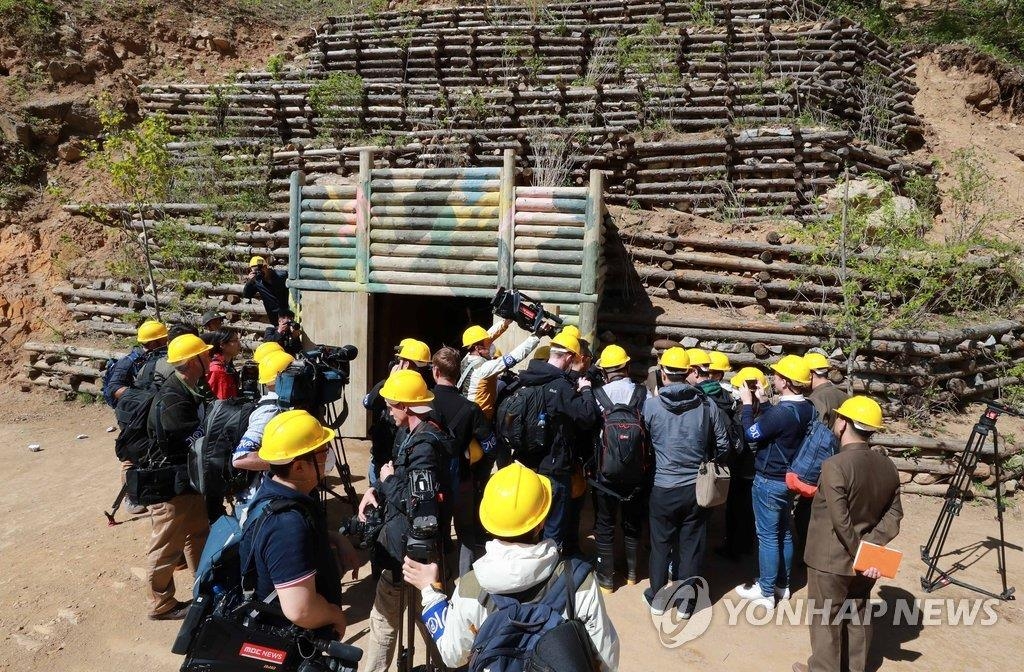 Des journalistes de la Corée du Sud et de quatre autres pays se tiennent devant le quatrième et plus grand tunnel du site d'essais nucléaires de Punggye-ri, le jeudi 24 mai 2018, avant le démantèlement. (Joint Press Corps-Yonhap)