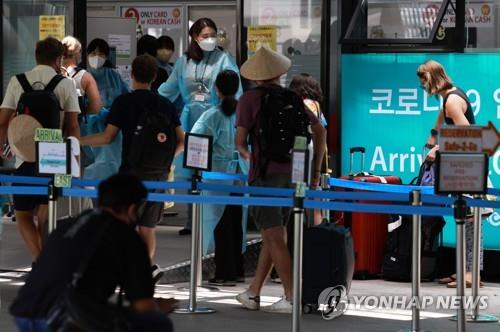Des voyageurs arrivant de l'étranger attendent de subir un test de dépistage pour le nouveau coronavirus (Covid-19) au centre réservé aux arrivées au terminal 1 de l'aéroport international d'Incheon, le vendredi 15 juillet 2022.
