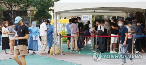Des personnes attendent le mardi 16 août 2022 de subir un test de dépistage du nouveau coronavirus (Covid-19) dans un centre provisoire à Séoul. 