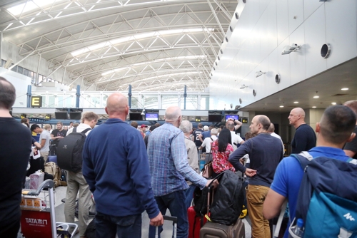 北京国際空港の高麗航空チェックインカウンターに並ぶ外国人乗客＝６日、北京（聯合ニュース）