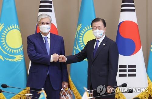 青瓦台であいさつする文大統領（右）とトカエフ大統領＝１７日、ソウル（聯合ニュース）