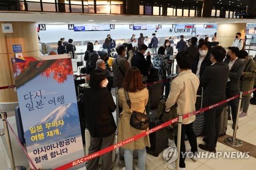 日本政府がビザなしでの短期滞在を再び認めた１１日、ソウルの金浦国際空港では日本に向かう観光客の長い列ができた。羽田行きの手続きを行っているアシアナ航空のカウンター＝（聯合ニュース）