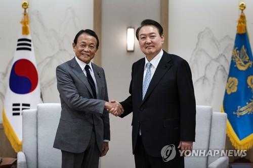 握手を交わす尹大統領と麻生氏（大統領室提供）＝（聯合ニュース）≪転載・転用禁止≫