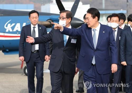 韓国航空宇宙産業を訪れ、展示されている戦闘機などを視察する尹大統領（手前）＝２４日、泗川（聯合ニュース）