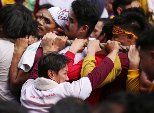 (마닐라 EPA=연합뉴스) '블랙 나자렌'(Black Nazarene) 퍼레이드에서 참가자들이 '검은 예수상'이 실린 수레를 끄는 밧줄을 잡고 있다.