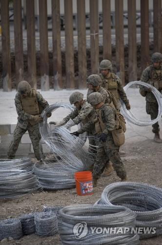 미군이 지난해 11월 샌디에고 인근 미·멕시코 국경 장벽 위에 가시철조망을 설치하고 있다. [EPA=연합뉴스]