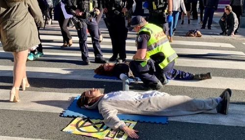 도로 연와 시위를 벌이는 남녀에게 해산을 권하는 호주 경찰