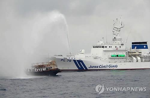 일본 해상보안청 순시선이 2017년 7월 동해 대화퇴어장 주변에서 불법 조업을 이유로 북한 어선을 향해 물대포를 쏘고 있다. (EPA=연합뉴스 자료사진)