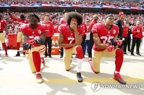 2016년 10월 미국프로풋볼(NFL) 샌프란시스코 포티나이너스(49ers) 쿼터백으로 활동했던 콜린 캐퍼닉(가운데)이 캘리포니아 산타클래라 경기장에서 미국 국가가 울려퍼지는 와중에 인종차별에 항의하는 뜻으로 무릎을 꿇고 있는 모습. [EPA= 연합뉴스]