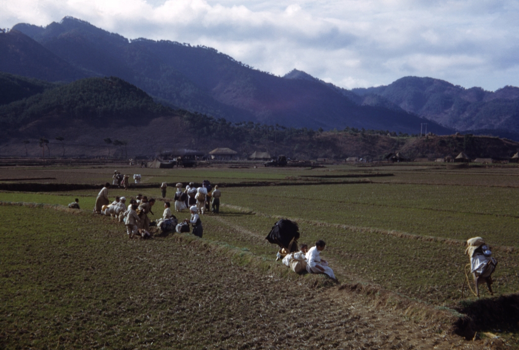 1951년 3월께 군 야전 캠프가 있는 산간마을을 지나는 피란민 행렬.