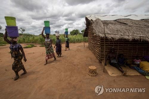 지난 23일 모잠비크 마루파 재정착 센터에서 여성들이 버킷으로 물을 나르고 있다.