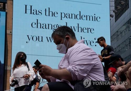 22일(현지시간) 미국 뉴욕의 타임스스퀘어에 마스크를 쓴 사람들이 앉아 있다. [AFP=연합뉴스]