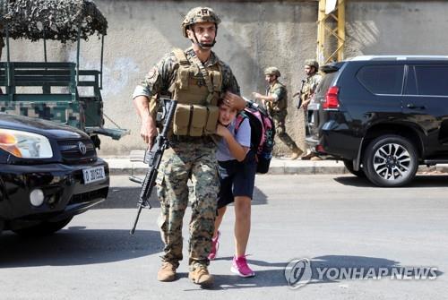 베이루트 총격전 와중에 겁에 질린 채 하교하는 여학생을 부모에게 데려다주는 군인