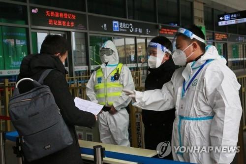 '전면봉쇄' 중국 시안 기차역서 여행객 서류 검사하는 경찰