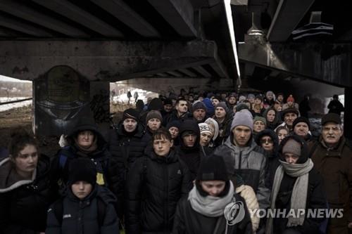 Ukrainian Irfin residents take refuge under the bombed bridge