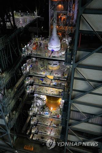 조립동 안의 작업대에 둘러싸인 SLS 로켓과 오리온 캡슐 