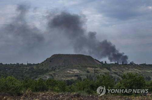 18일 우크라이나 리시찬스크의 광산폐기물 더미 근처에서 포격에 연기가 솟고 있다.