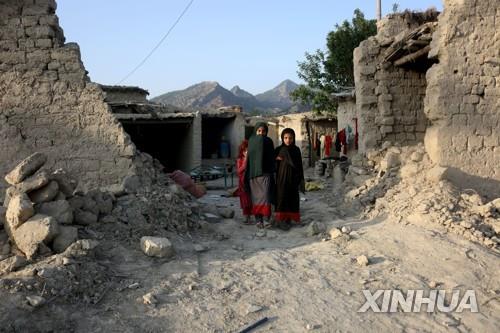 강진으로 훼손된 아프간 호스트주의 마을에 서 있는 주민.