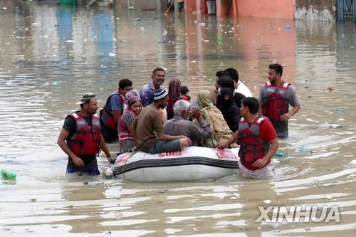폭우로 고립된 카라치 주민이 구조대와 함께 보트로 이동하는 모습.