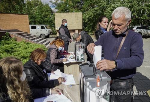 (마리우폴<도네츠크주> EPA=연합뉴스) 우크라이나 동남부 도네츠크주 마리우폴의 야외 투표소에서 25일(현지시간) 한 주민이 투표하고 있다. 2022.09.25