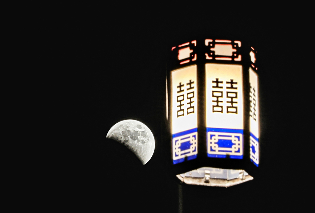 한옥마을 가로등 옆으로 보이는 달. 개기월식이 진행되고 있다. [사진/진성철 기자]