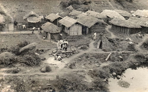 한국전쟁이 끝난 후 지어진 초가집 마을에서 마을 공용인 디딜방아를 찧은 주민들. 1954년 [임인식 제공]