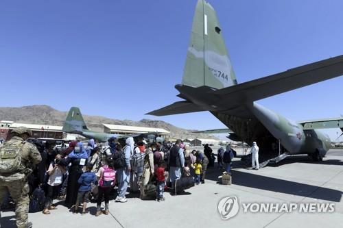 아프간 특별기여자들이 2021년 8월 카불공항에서 우리 공군 C-130J 수퍼허큘리스 수송기에 탑승하기 위해 대기하고 있는 모습 [연합뉴스 자료사진. 공군제공. 재판매 및 DB 금지]