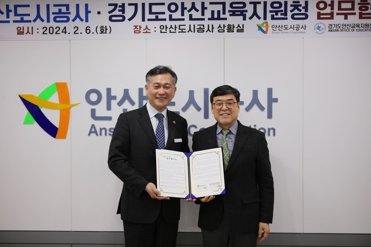 Gyeonggi Urban Development Corporation President Heo Sung (left) and Ansan Education Support Director Kim Tae-hoon sign a business agreement.