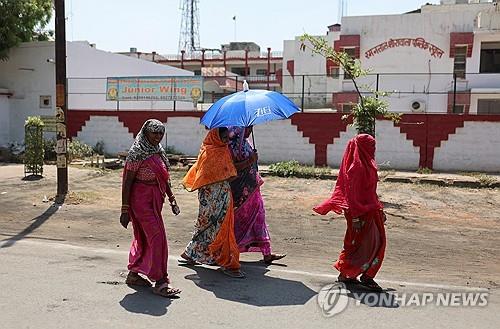 4월 26일 인도 우타르프라데시에서 양산을 쓰고 투표장을 떠나는 여성 유권자들.