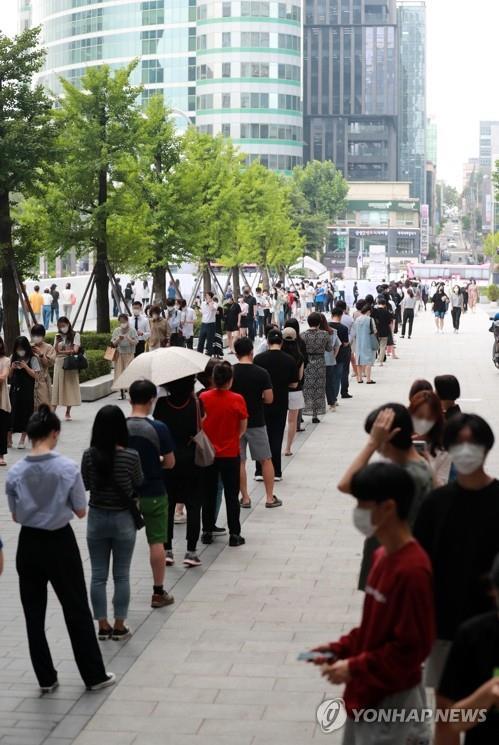 Los ciudadanos esperan en fila para ser examinados del coronavirus, el 8 de julio de 2021, en una clínica provisional, en Seúl.