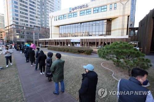 Las personas esperan en fila, el 1 de diciembre de 2021, para ser examinadas del coronavirus en una clínica provisional en el distrito de Songpa, en Seúl.