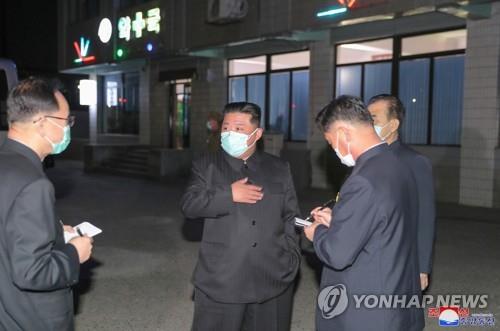 La foto sin fechar, publicada por la KCNA, muestra al presidente del Comité de Asuntos de Estado norcoreano, Kim Jong-un (centro), utilizando una mascarilla, en medio del brote del COVID-19, mientras inspecciona una farmacia de Pyongyang. (Prohibida su reventa y archivo)